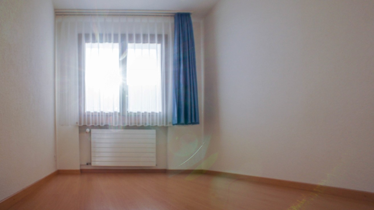 Leerer Wohnraum mit Fenster und Heizkörper