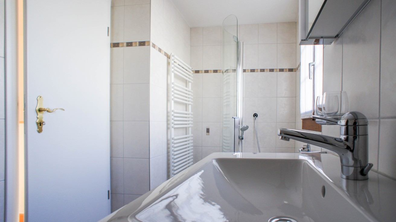 Helles Badezimmer mit Waschbecken und Dusche