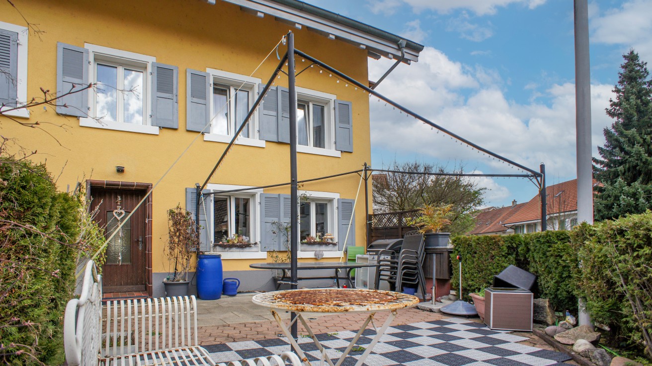 Gelbes Einfamilienhaus mit Terrasse