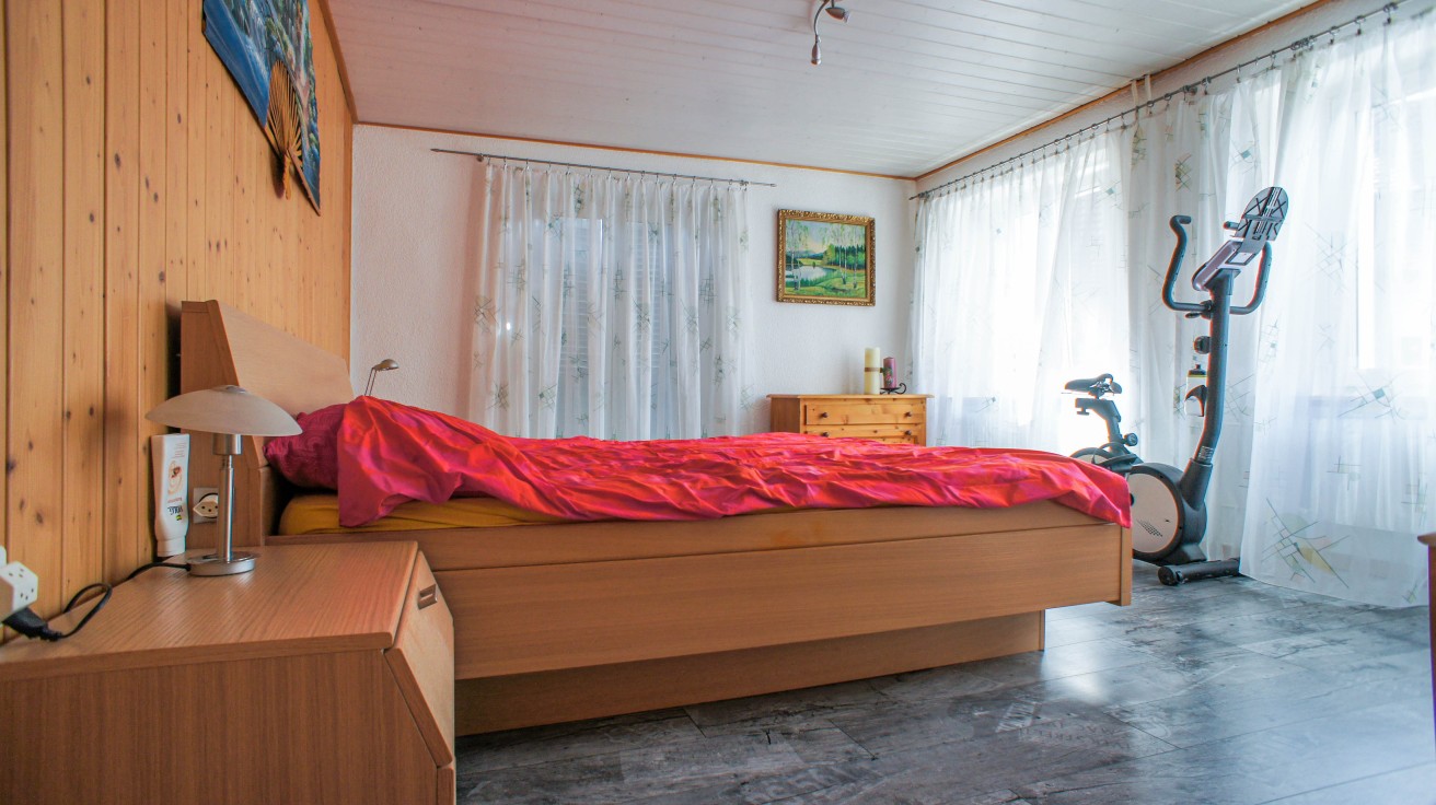 Schlafzimmer mit Holzvertäfelung und Trainingsgerät