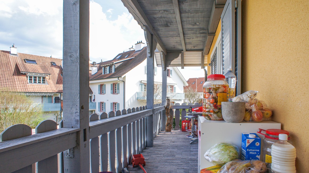 Überdachter Balkon mit Nachbarhäusern