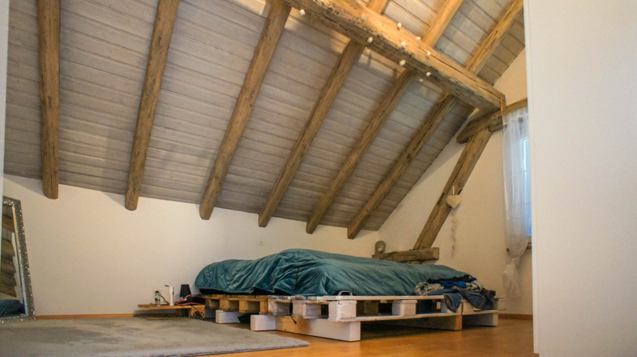 Schlafzimmer im Dachgeschoss mit sichtbaren Holzbalken