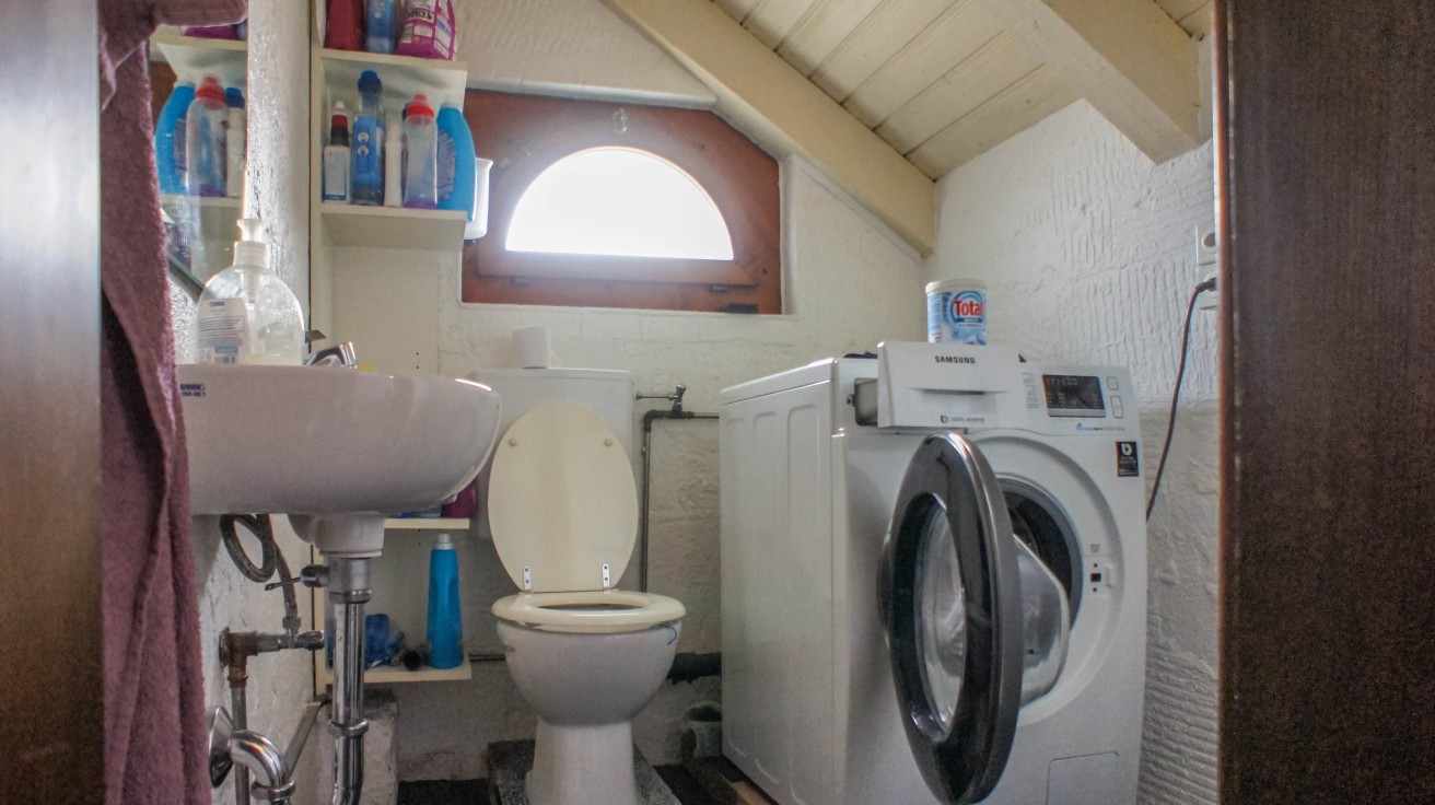 Badezimmer mit Waschtisch, WC und Waschmaschine