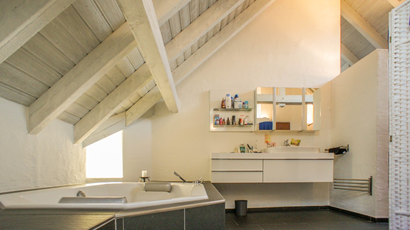 Dachgeschoss-Badezimmer mit Whirlpool und Waschtisch