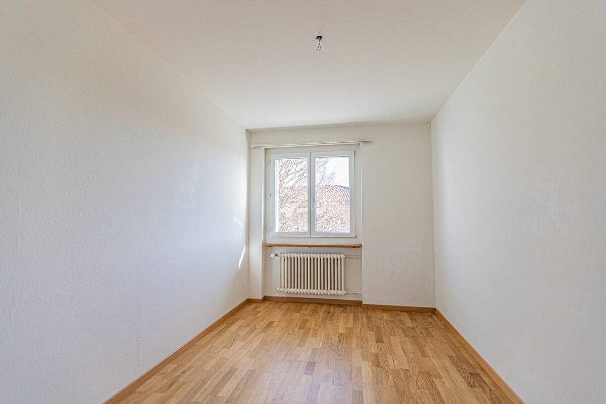 Leerer heller Raum mit Fenster und Heizkörper