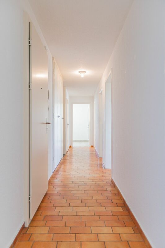 Langer heller Flur mit Terrakotta-Boden