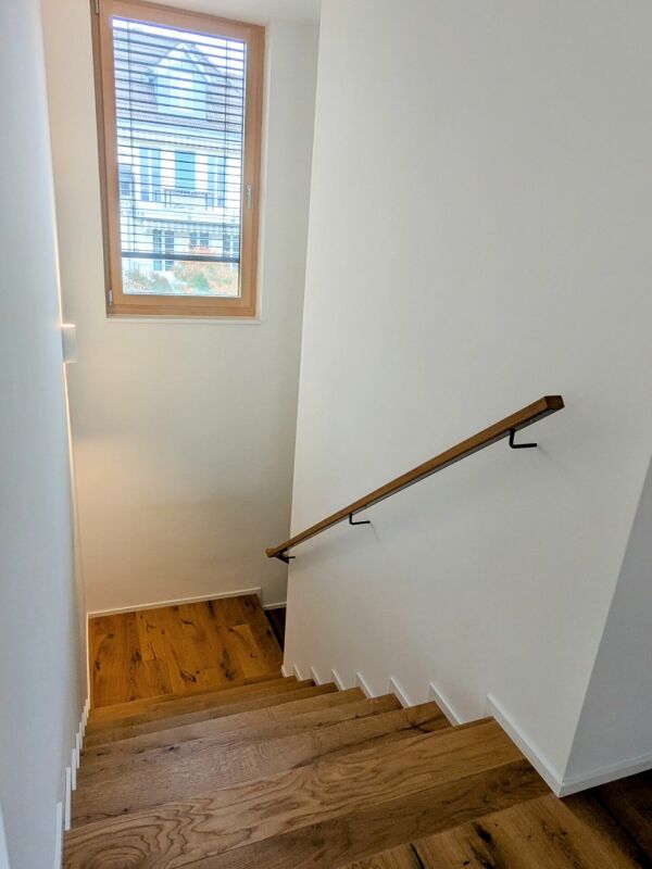Treppenhaus mit Holztreppe und Fenster