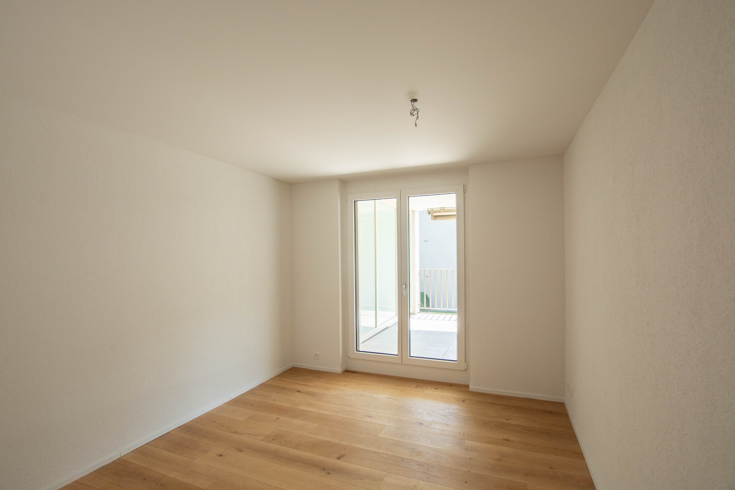 Leeres helles Zimmer mit Balkonzugang