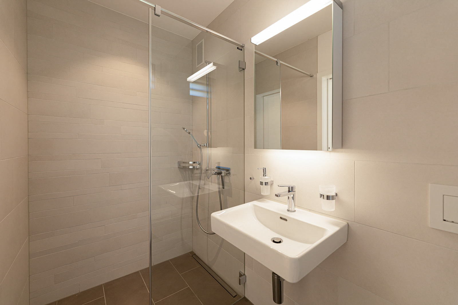 Modernes Badezimmer mit Glasdusche und Waschtisch