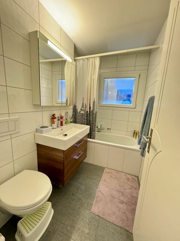 Kleines, modernes Badezimmer mit Badewanne und Waschtisch