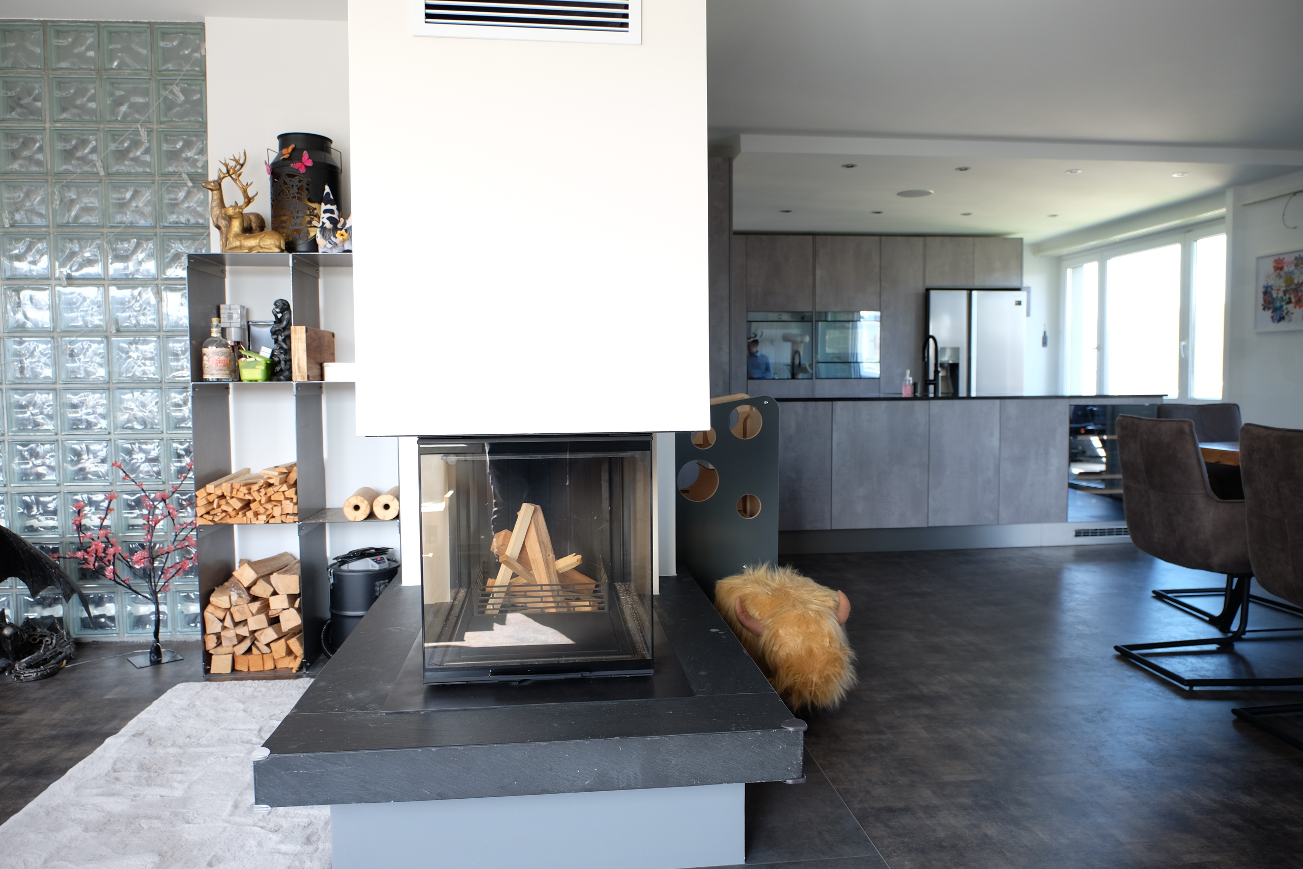 Moderner Wohnraum mit Kamin und offener Küche
