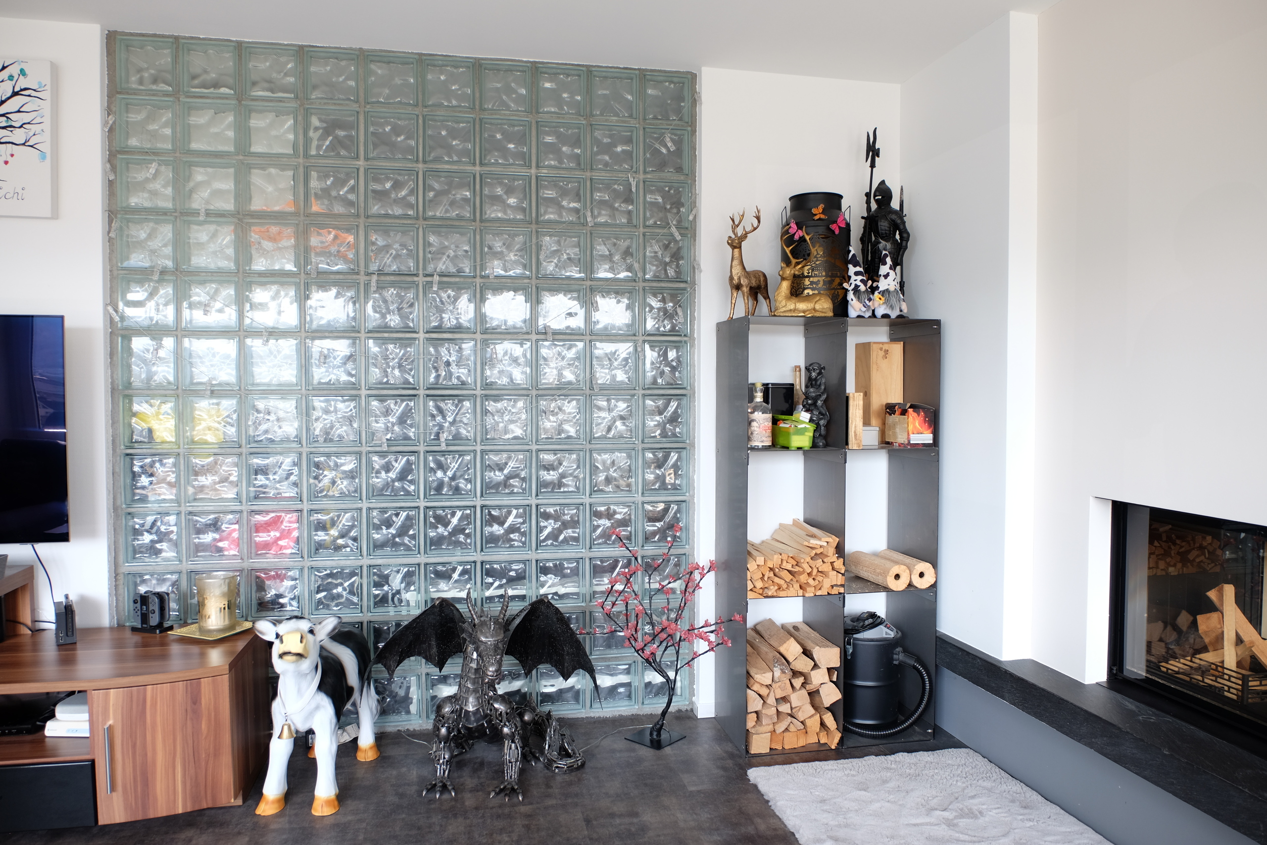 Wohnzimmer mit Kamin und dekorativer Glaswand
