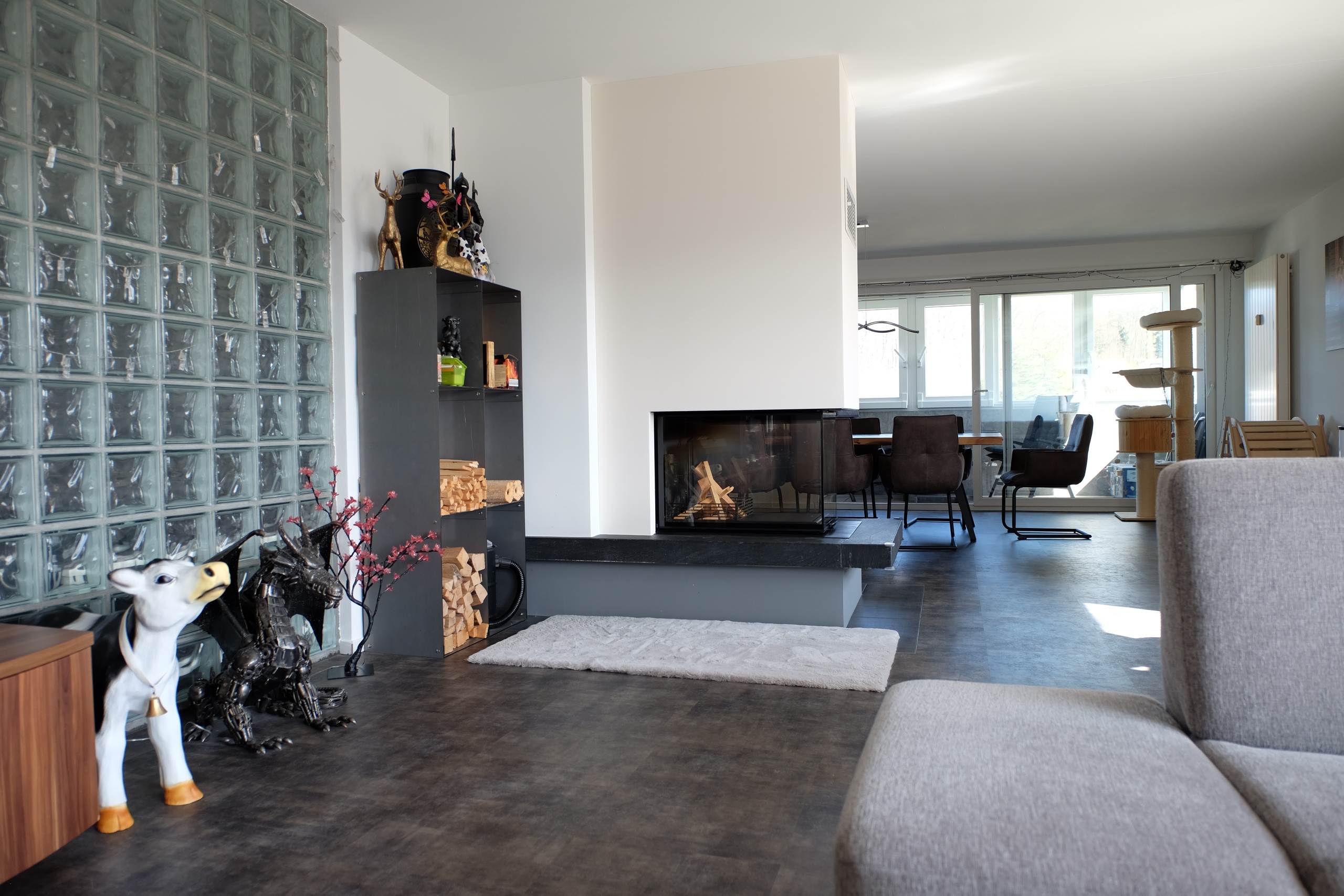Wohnzimmer mit Kamin und offener Esszone