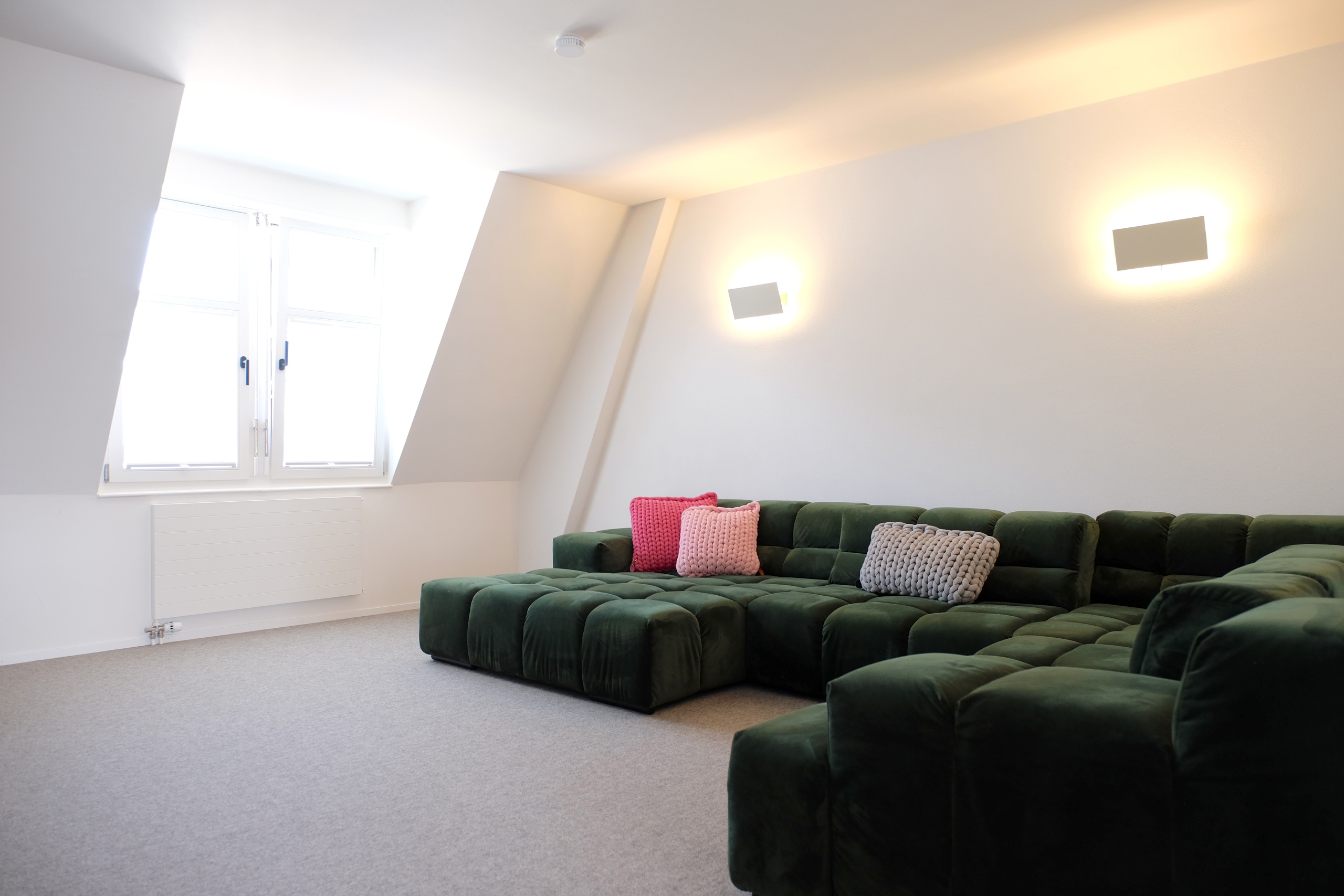 Helles Dachgeschoss-Wohnzimmer mit grünem Ecksofa