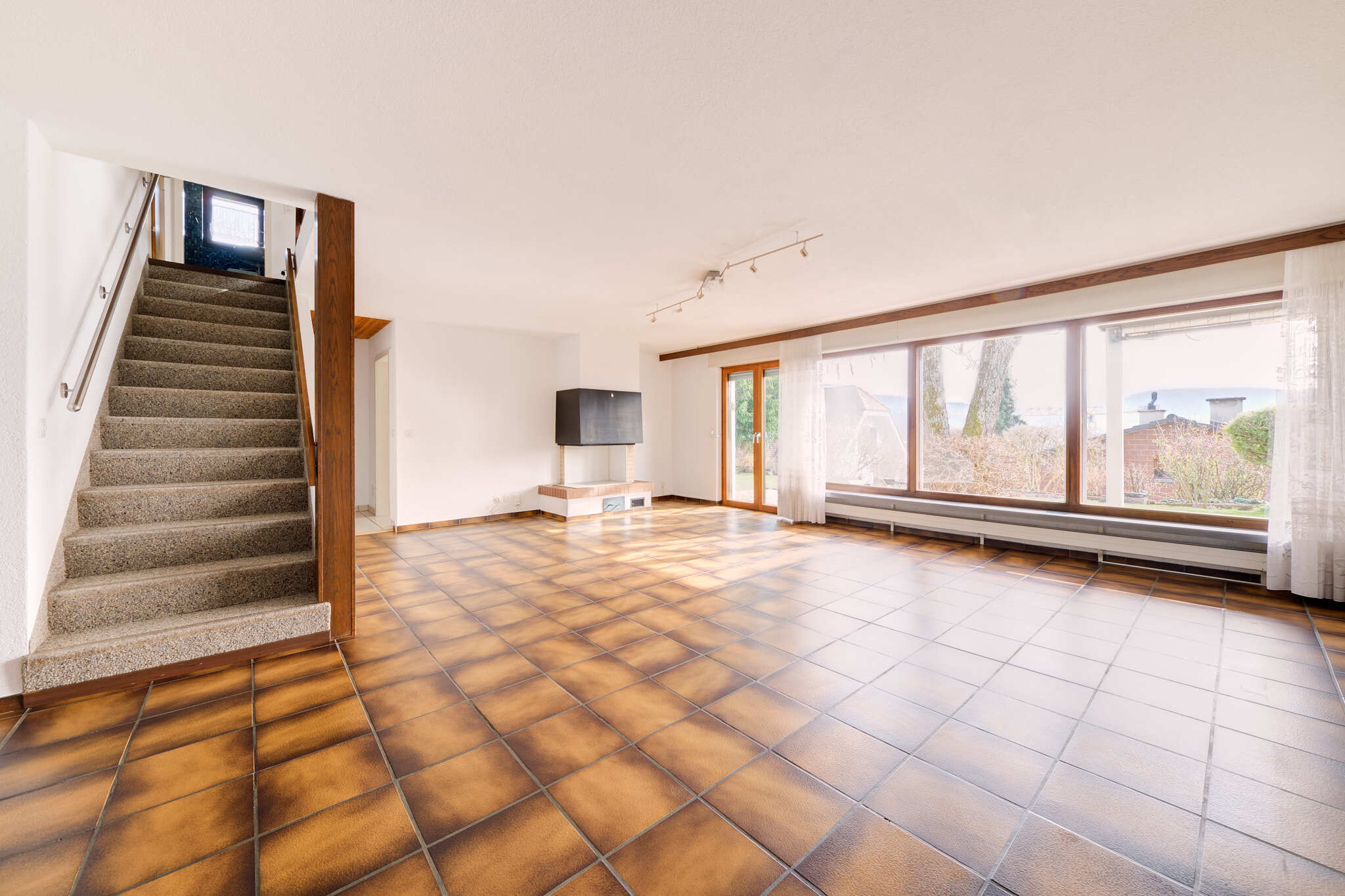 Heller Wohnraum mit Treppe und großer Fensterfront