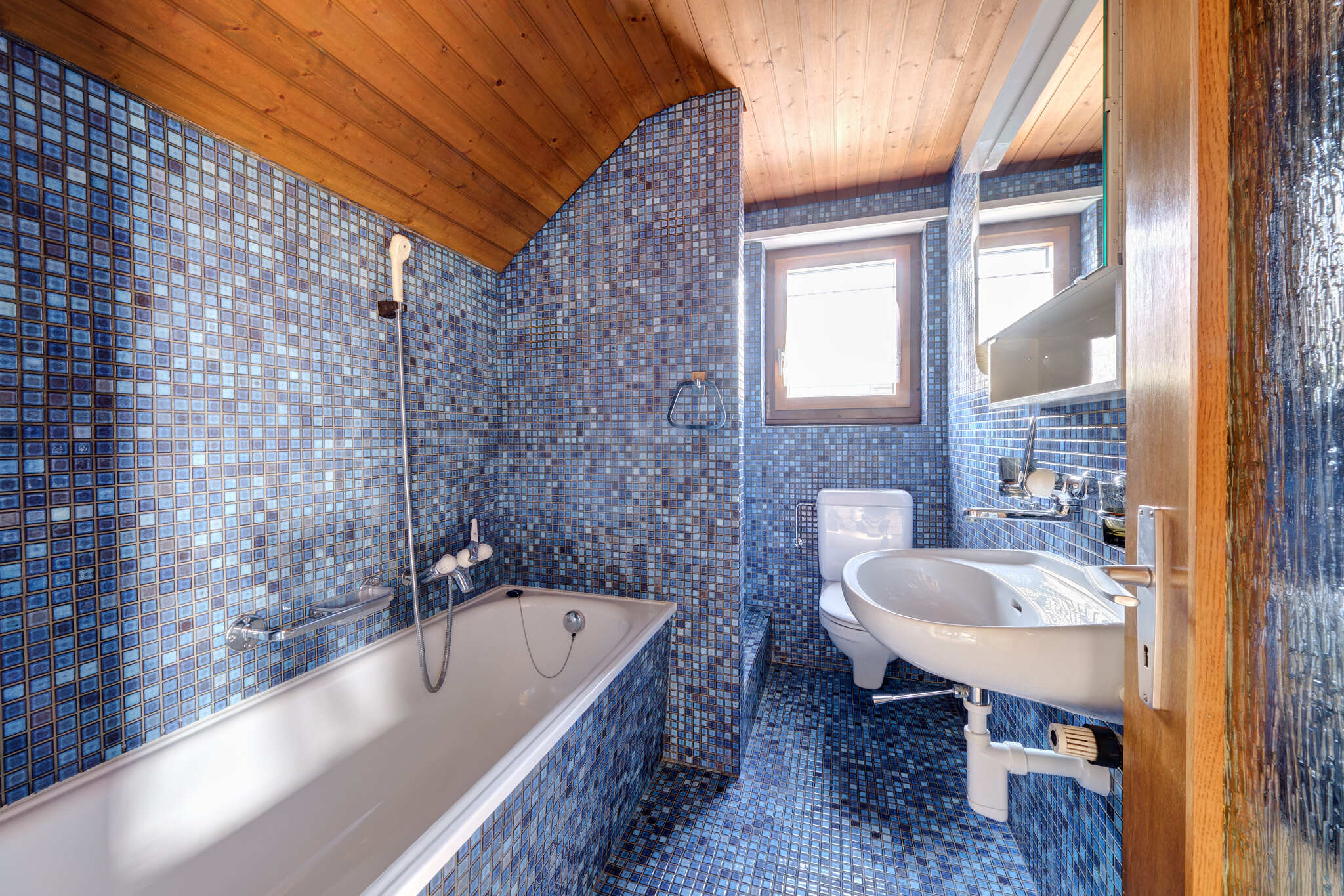 Badezimmer mit blauem Mosaik und Holzdecke