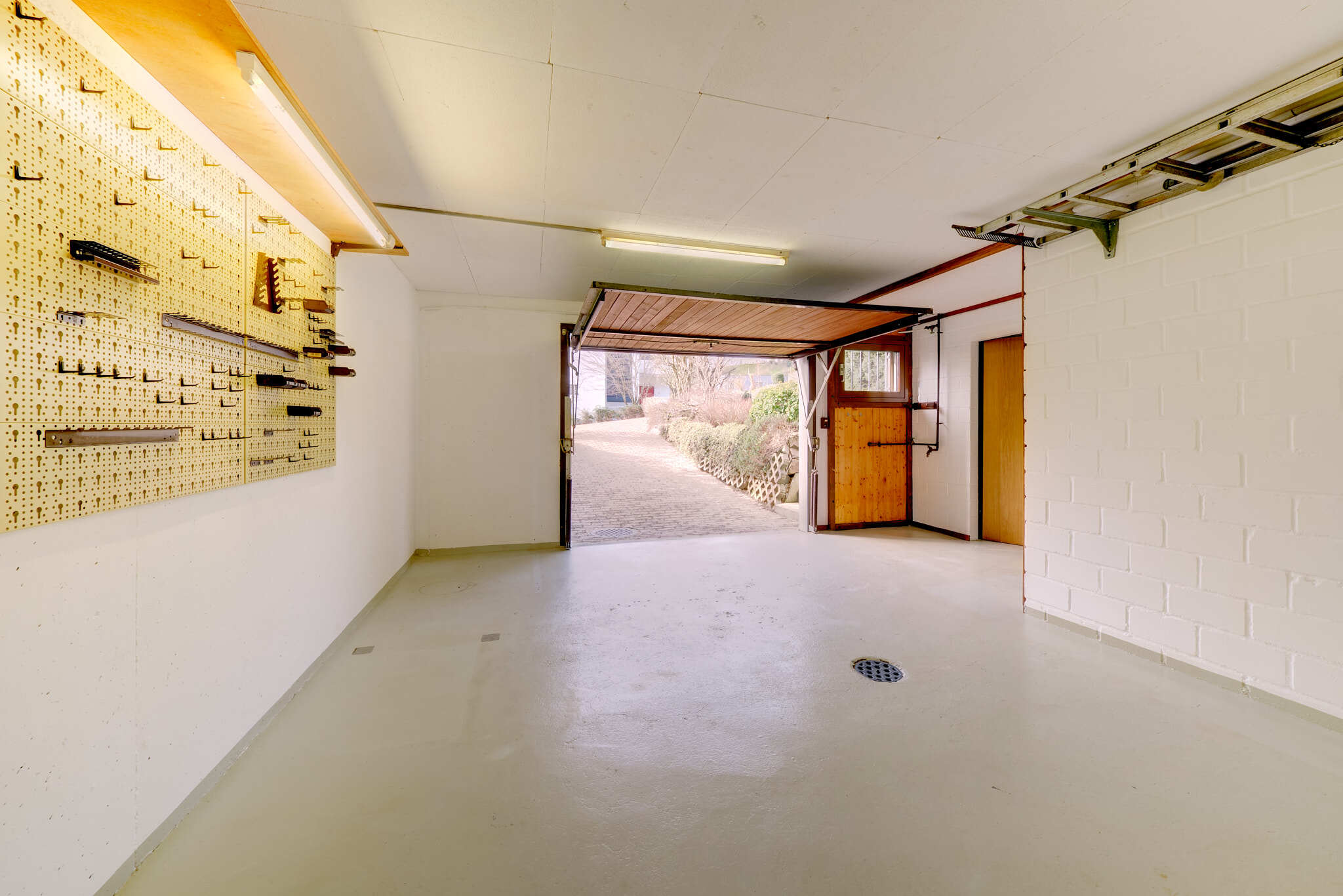 Garage mit offener Torfront und Werkstattwand