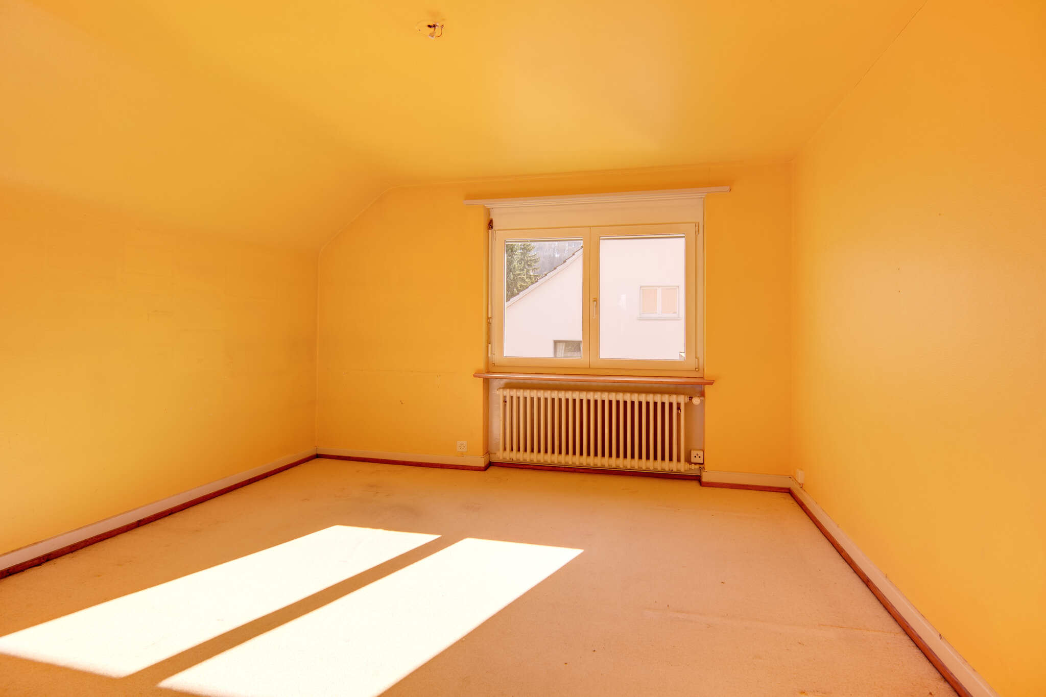 Leerer Dachraum mit Fenster und Heizkörper