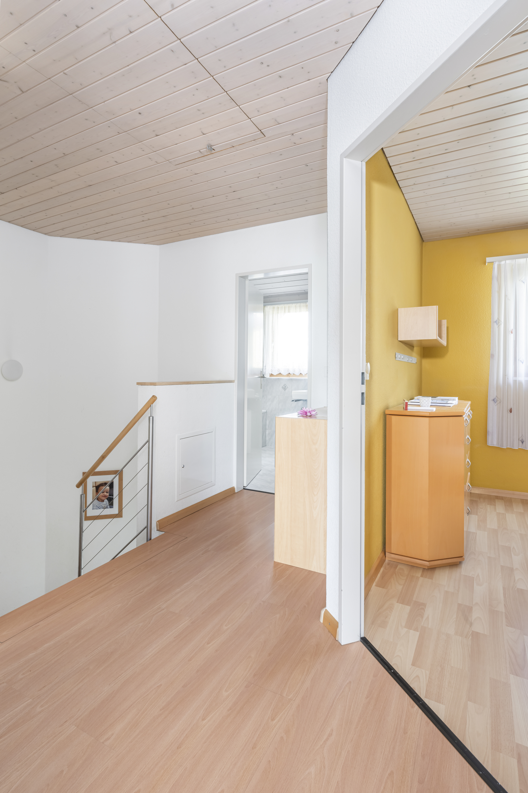 Heller Flur mit Treppe und angrenzendem Raum