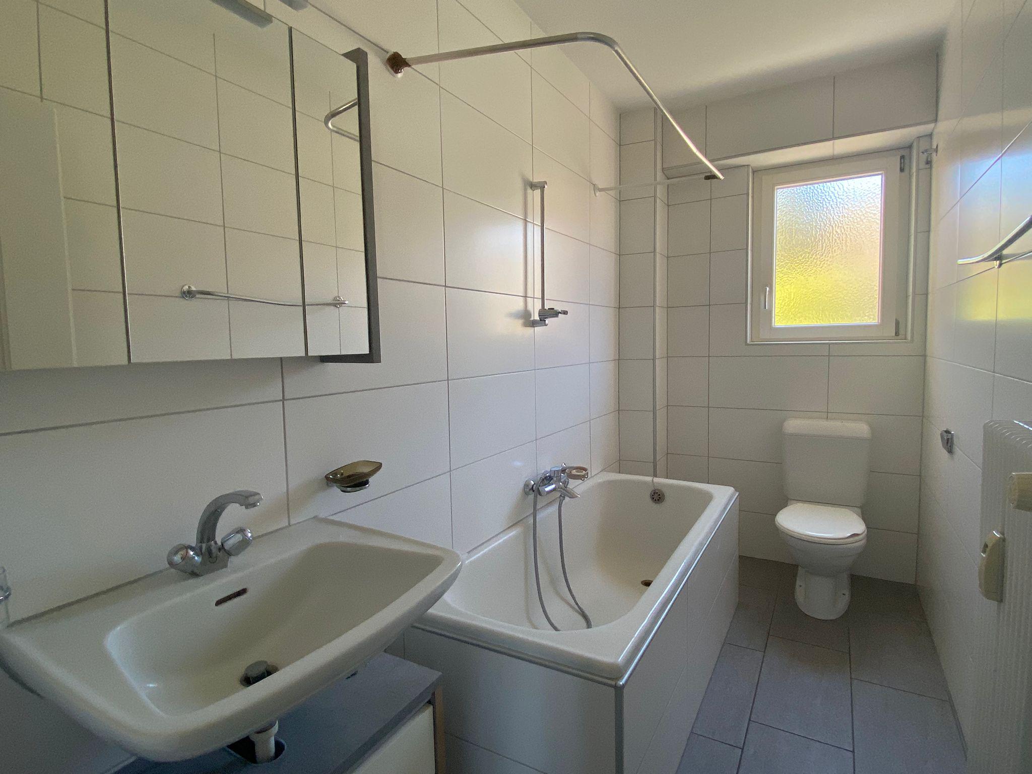Helles Badezimmer mit Badewanne, Waschtisch und WC