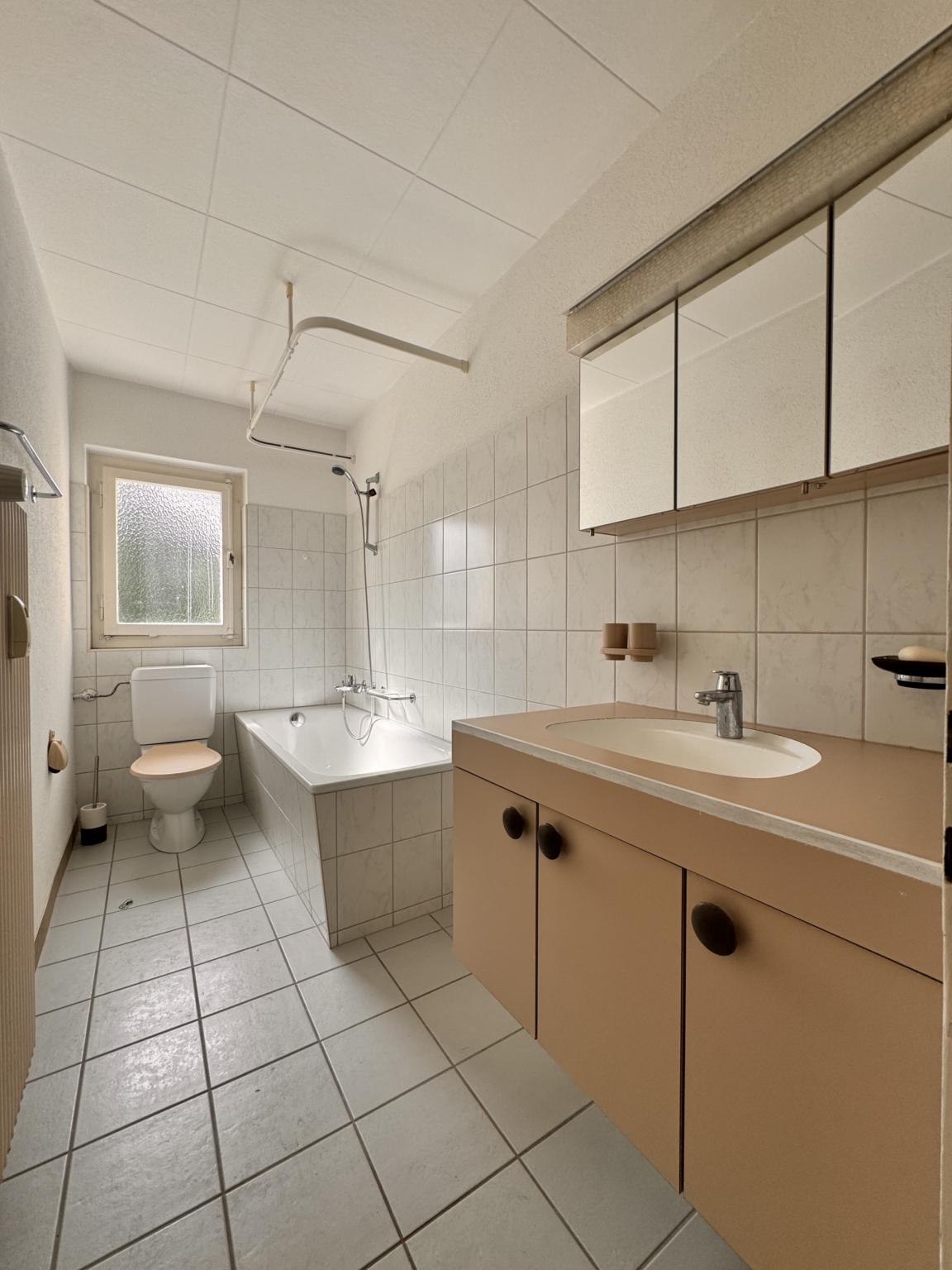 Badezimmer mit Badewanne und Waschtisch