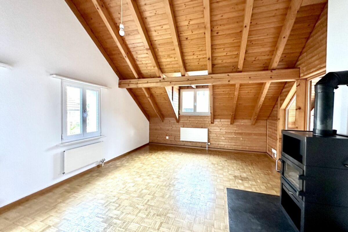 Ausgebauter Dachraum mit Holzdecke und Ofen