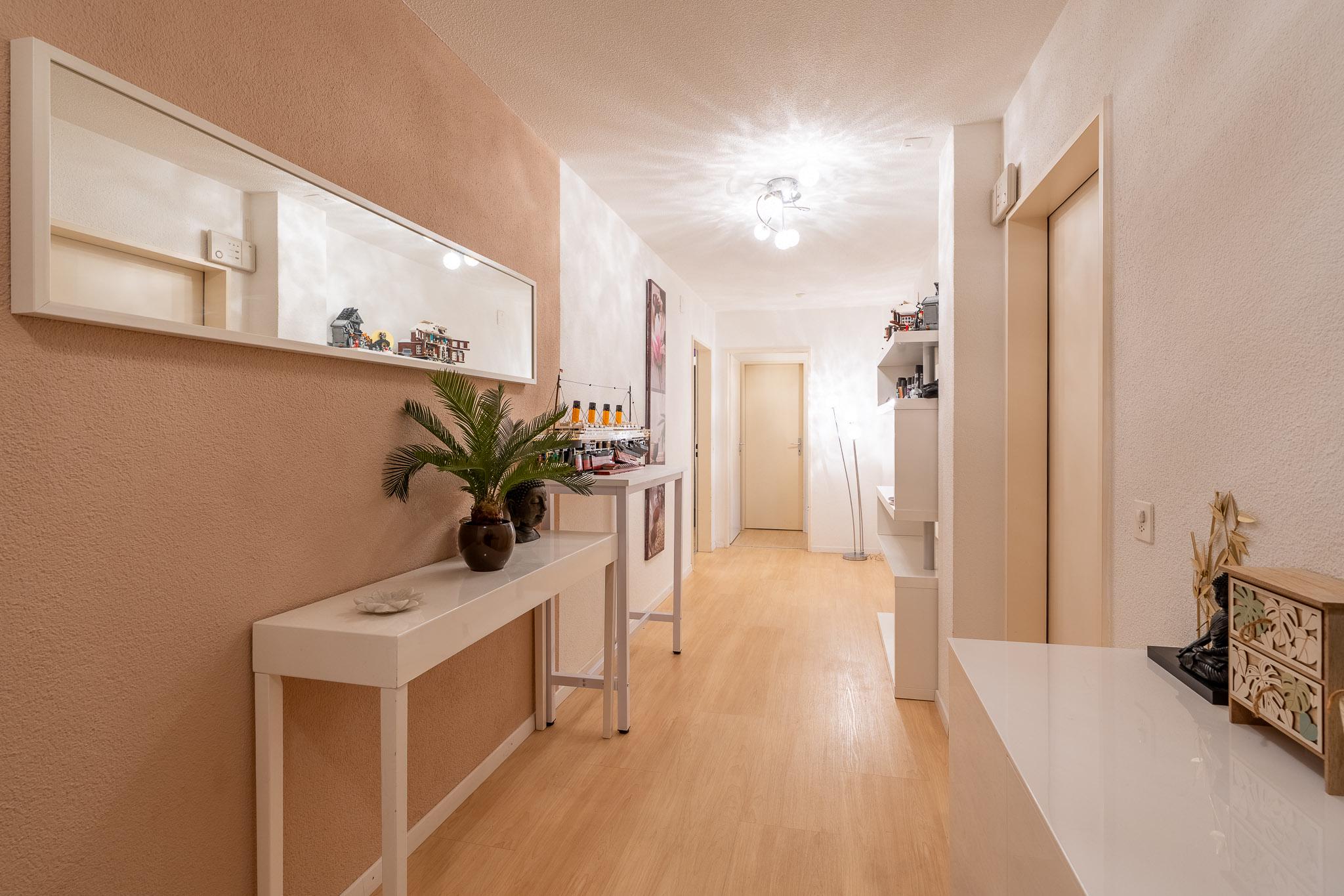Heller Flur mit Holzoptik und weißer Einrichtung