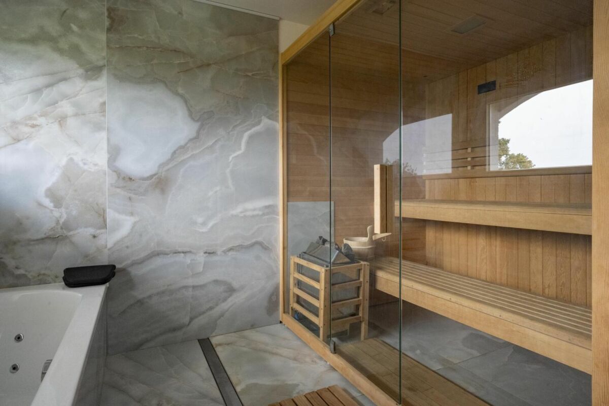 Sauna mit Natursteinwand und Glasfront