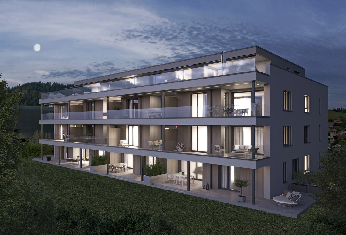 Modernes Mehrfamilienhaus mit großen Balkonen bei Dämmerung