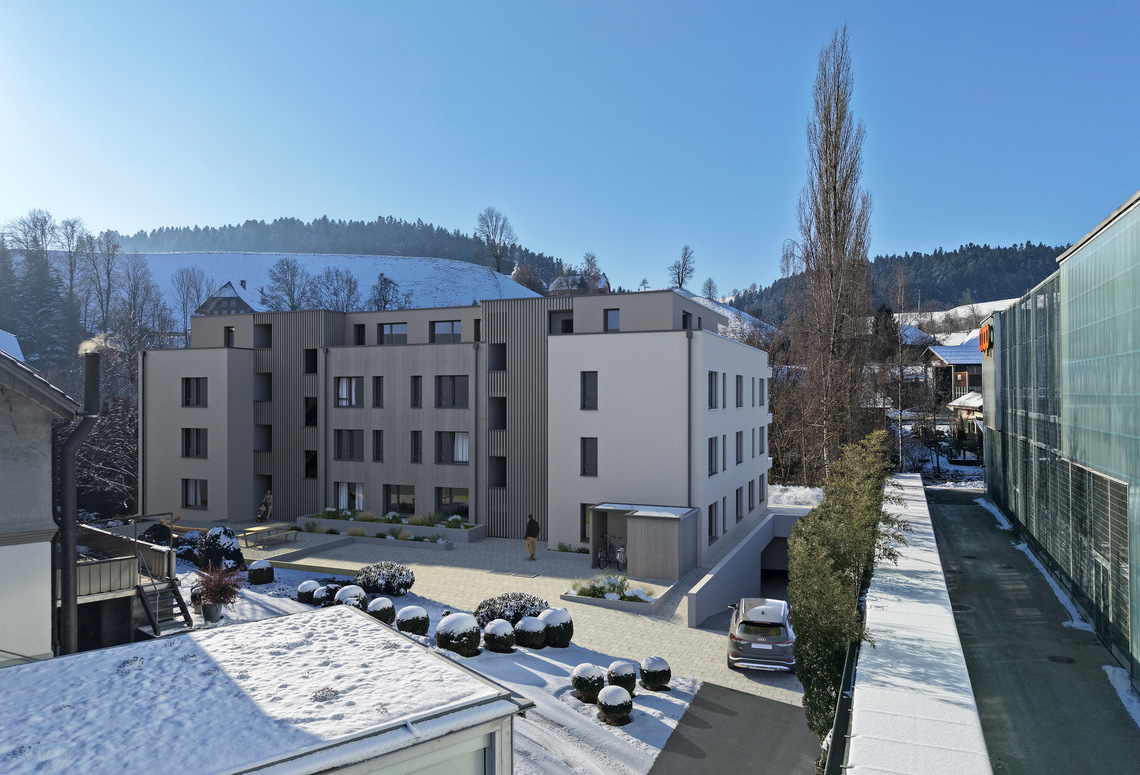 Modernes Mehrfamilienhaus mit winterlichem Innenhof