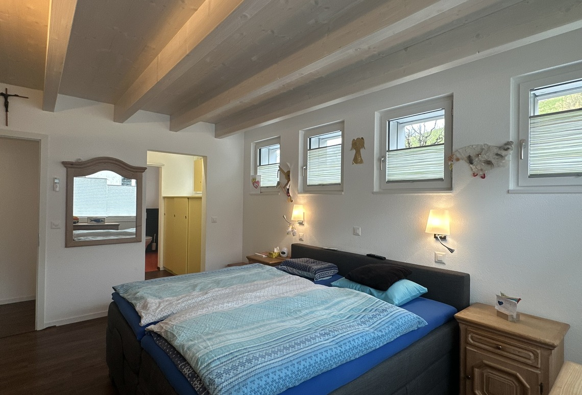 Gemütliches Schlafzimmer mit sichtbaren Holzbalken
