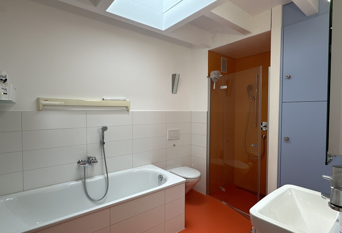 Modernes Badezimmer mit orangefarbener Duschzone