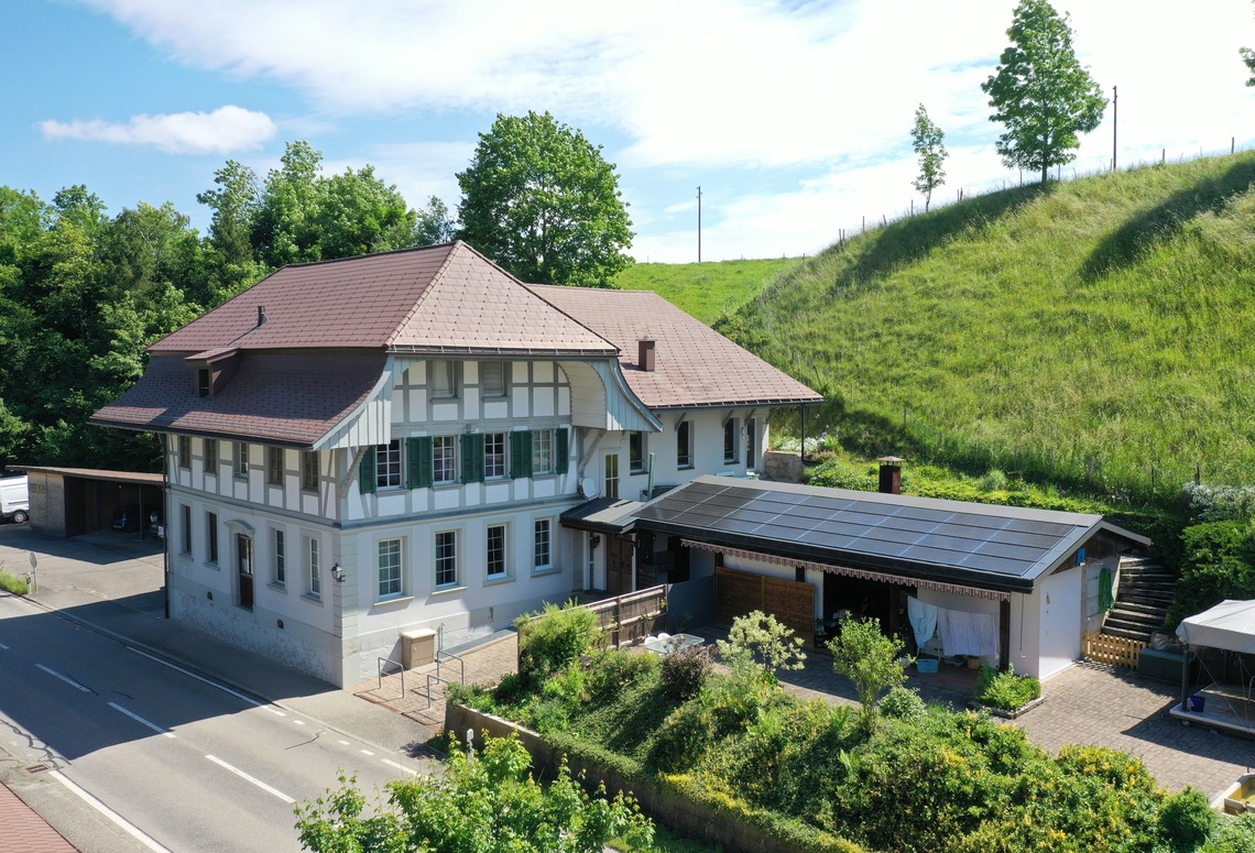 Historisches Wohnhaus mit begrüntem Hang und Solardach
