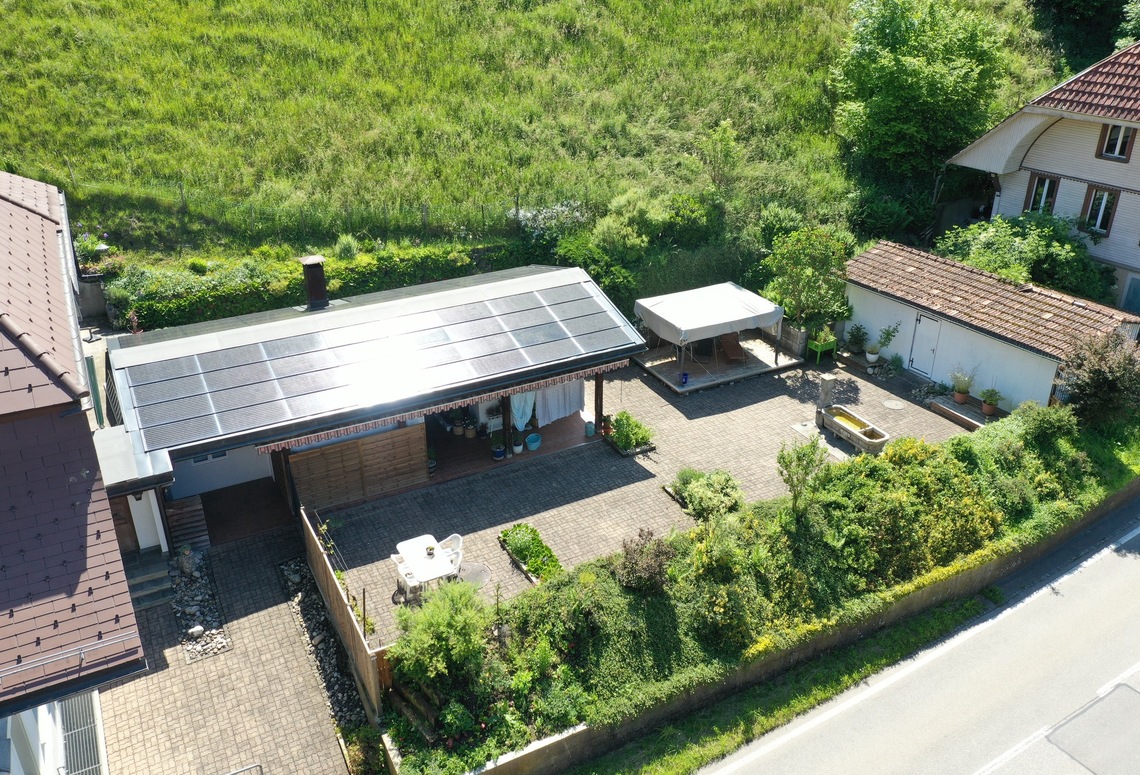 Drohnenaufnahme eines begrünten Grundstücks mit Nebengebäude und Solardach