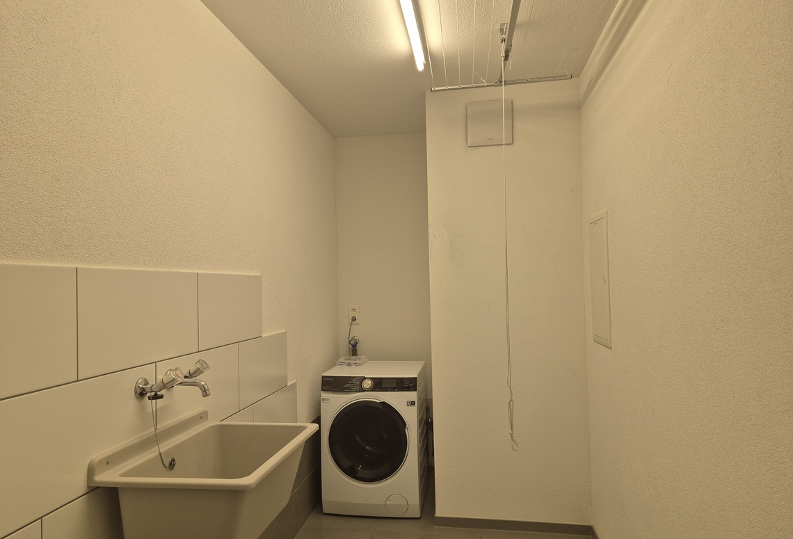Hauswirtschaftsraum mit Waschbecken und Waschmaschine