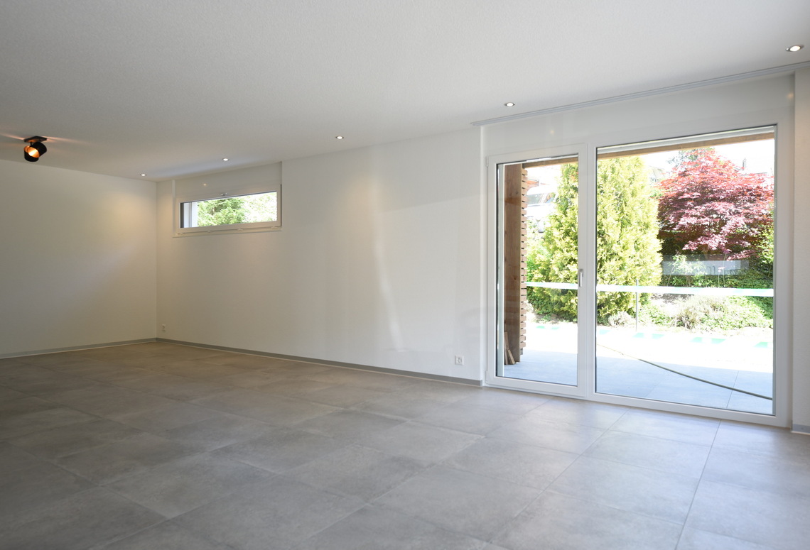 Leerer, moderner Wohnraum mit Terrassentür