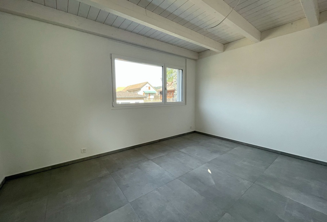 Leerer heller Raum mit sichtbaren Deckenbalken