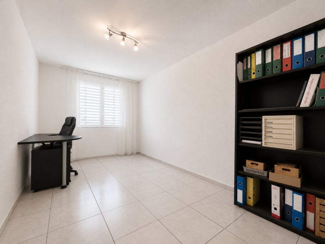 Helles Arbeitszimmer mit Schreibtisch und Regalsystem