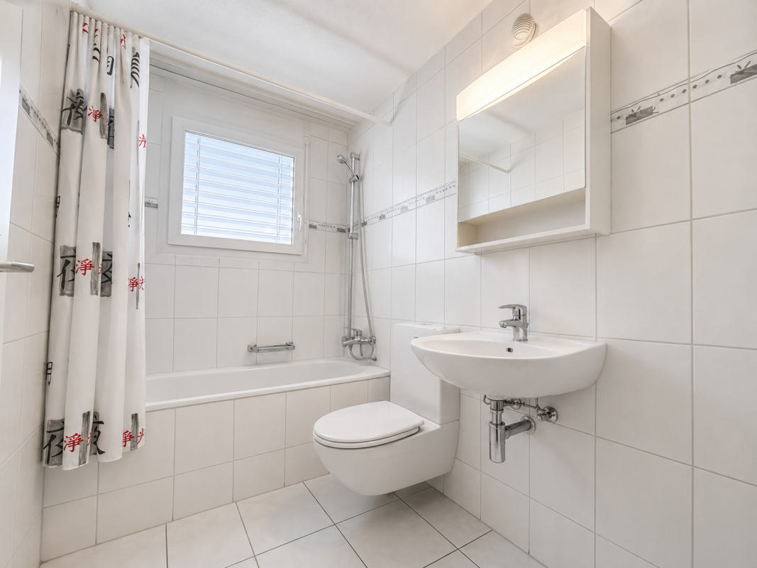 Helles Badezimmer mit Badewanne, WC und Waschtisch