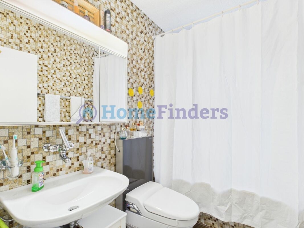 Gäste-WC mit Mosaikfliesen und weißem Duschvorhang