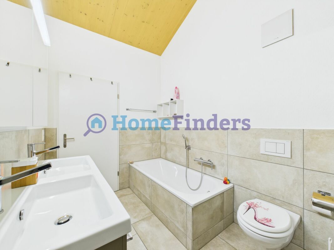 Helles Badezimmer mit Badewanne und Doppelwaschtisch