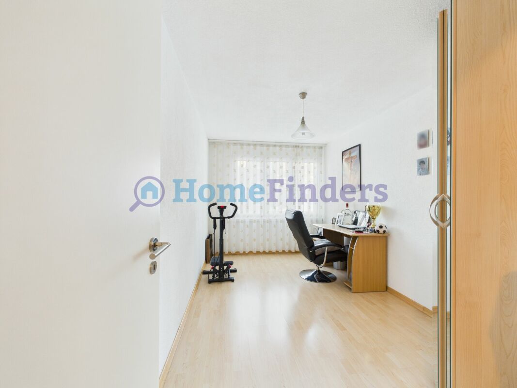 Arbeitszimmer mit Schreibtisch und Fitnessgerät