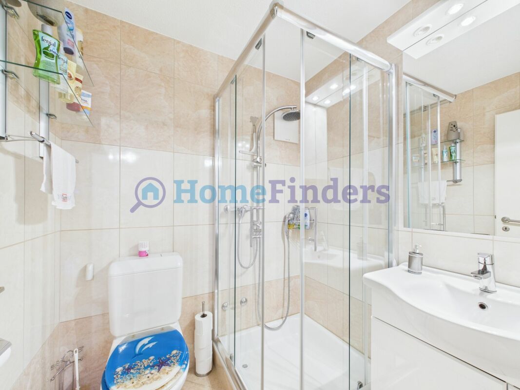 Badezimmer mit Glasdusche und WC