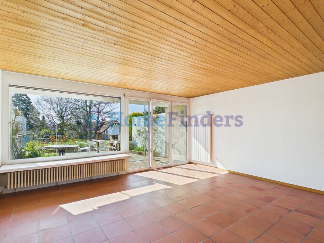Heller Raum mit Holzdecke und großer Fensterfront