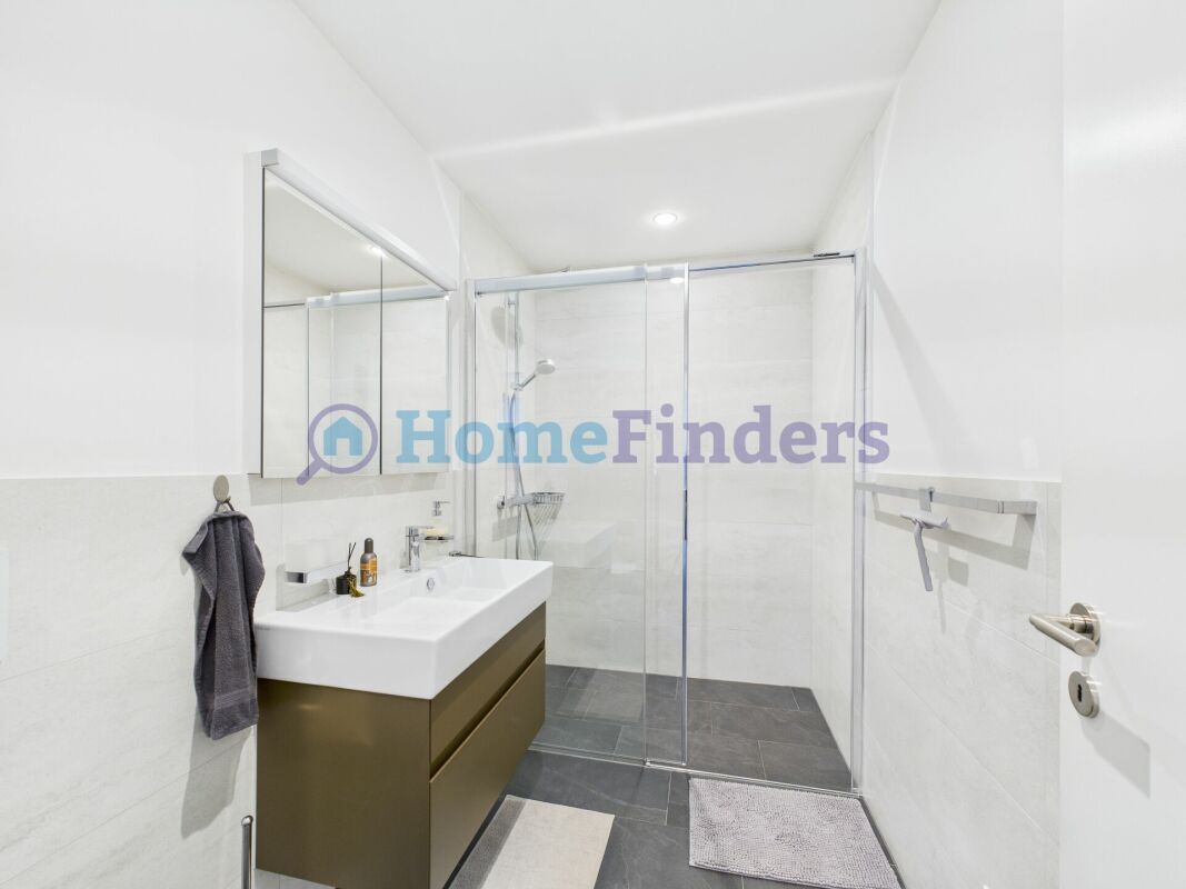 Modernes Badezimmer mit Glasdusche und Waschtisch