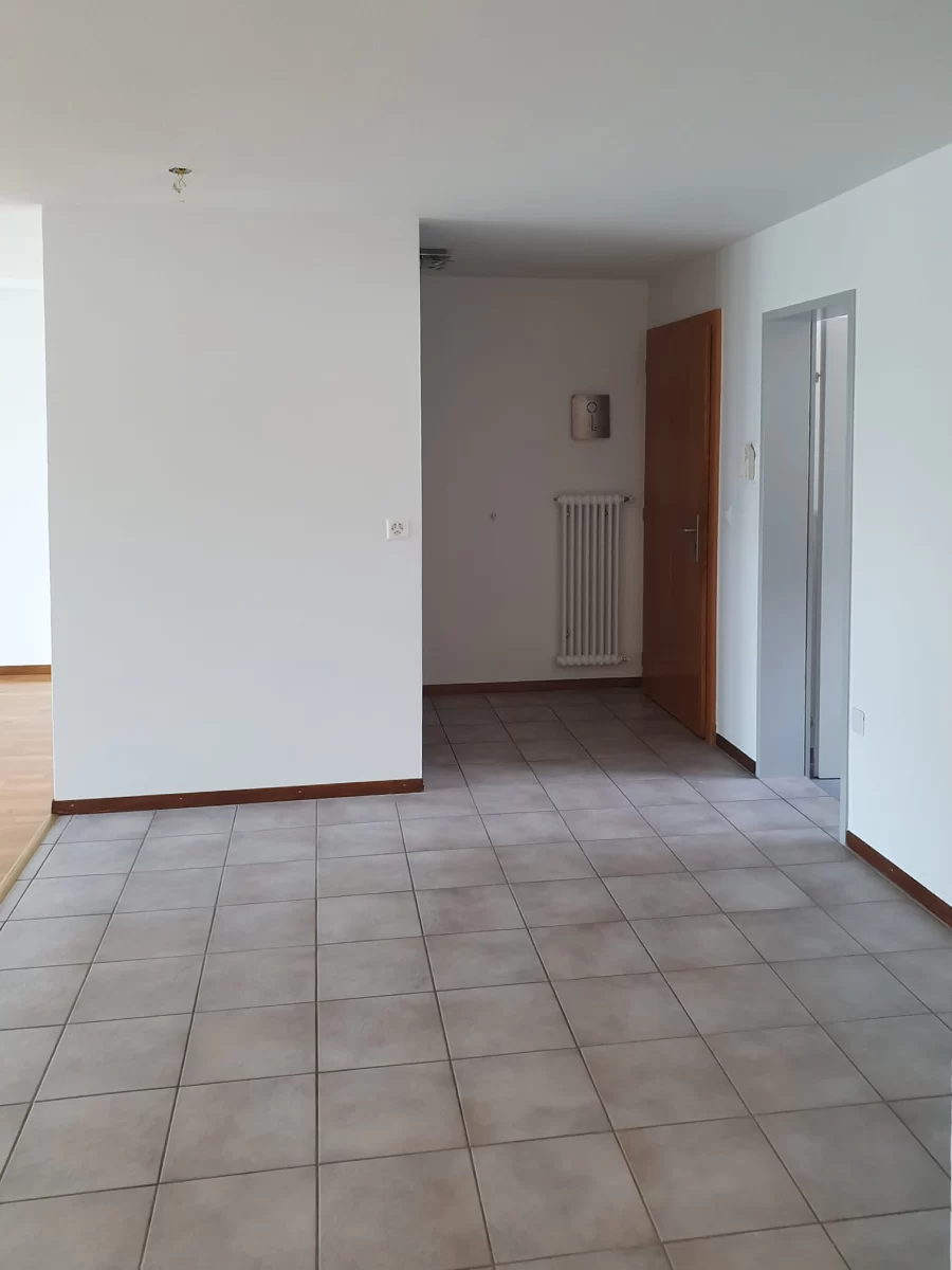 Leerer gefliester Wohnbereich mit Durchgang