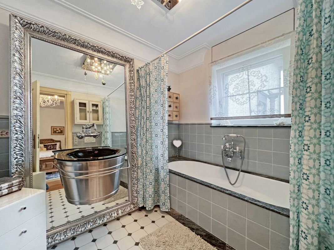 Badezimmer mit klassischer Ausstattung und großem Spiegel