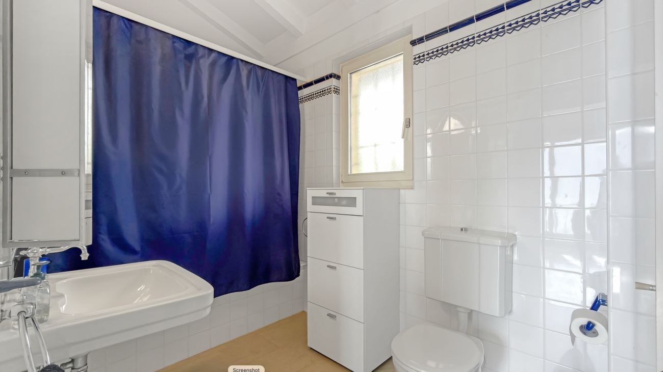 Badezimmer mit Fenster und Duschvorhang