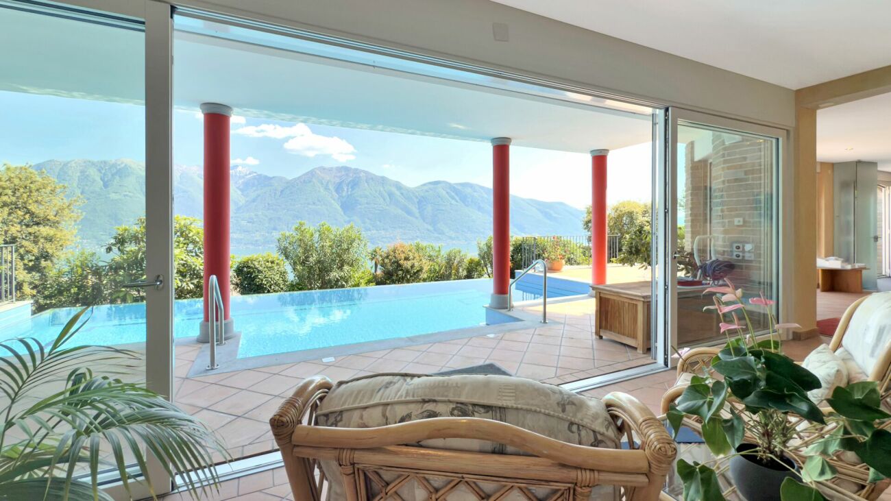 Wohnraum mit Panoramablick auf Pool und Berge