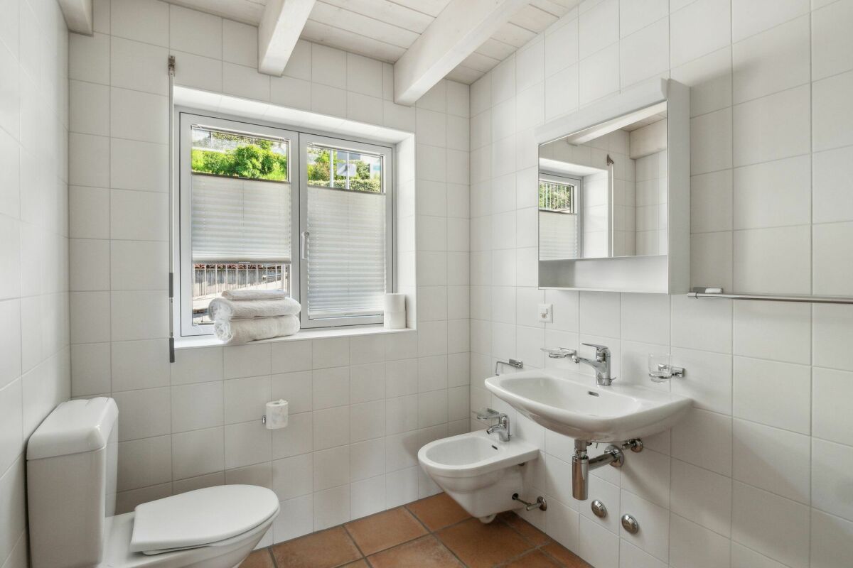 Helles Badezimmer mit Fenster und Wand-WC